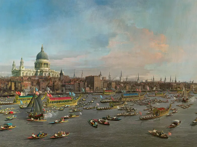 Eine historische Ansicht von London am Fluss Thames, mit zahlreichen Booten und Schiffen, die unterwegs sind. Im Hintergrund ist die St. Paul's Cathedral sichtbar, umgeben von städtischen Gebäuden und einem klaren Himmel.